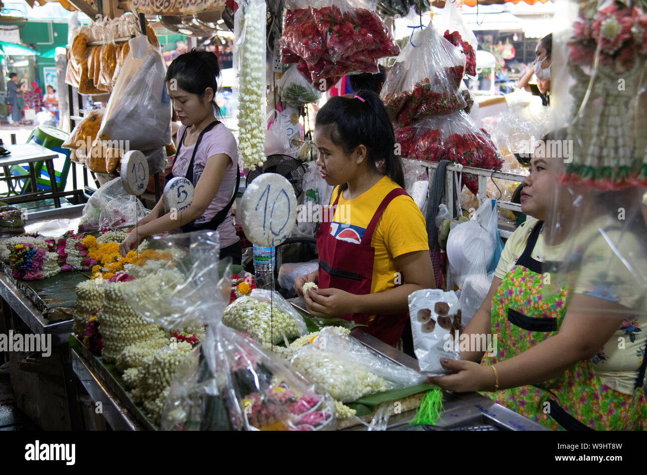 Mitarbeitende, die blumenarrangements in Pak Khlong Talat Flower Market in Bangkok Stockfoto