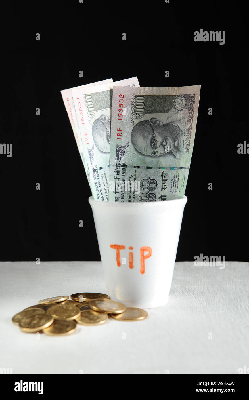 Einweg-Glas mit indische Banknoten Stockfoto