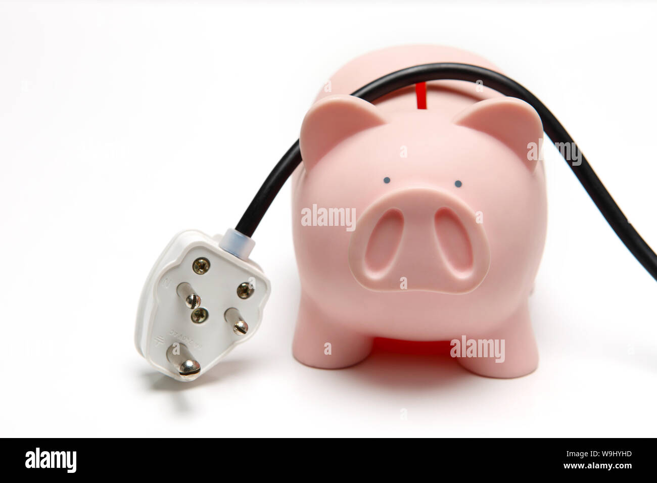 Elektrische Stecker auf ein Sparschwein Stockfoto