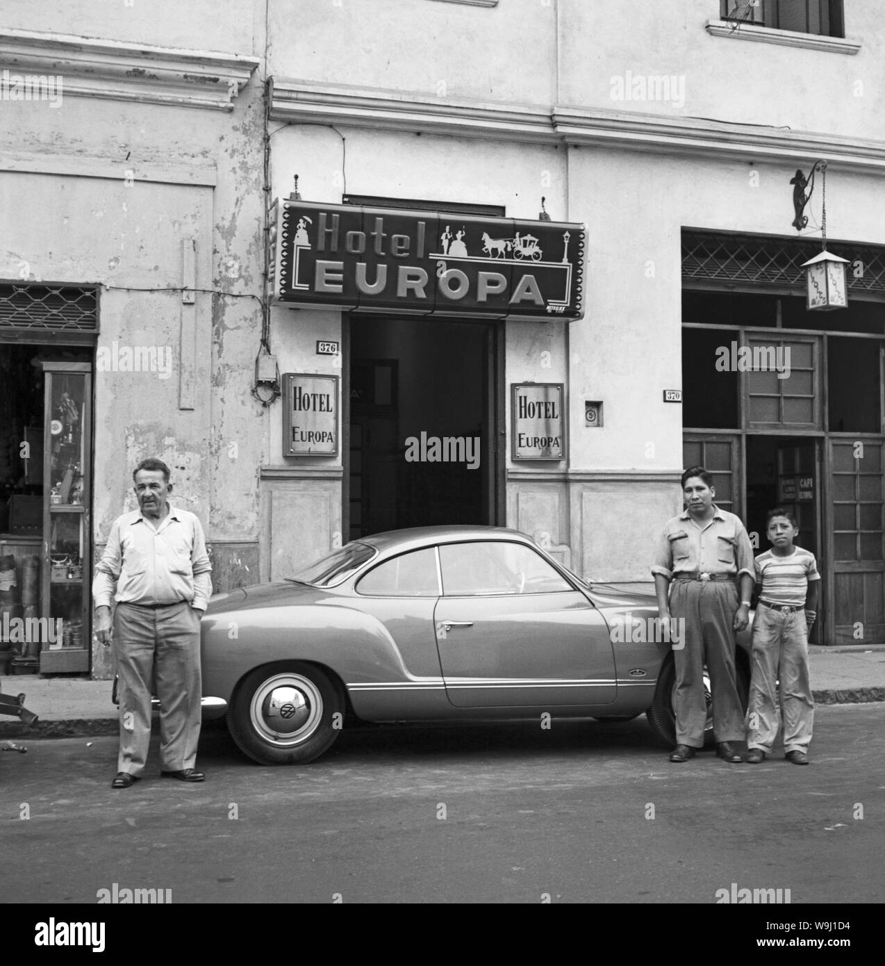 Männer mit einem VW Karmann Ghia vor dem Hotel Europa in Lima, Peru, 1960er Jahre. Männer mit einem Volkswagen Karmann Ghia vor dem Hotel Europa in Lima, Peru 1960. Stockfoto