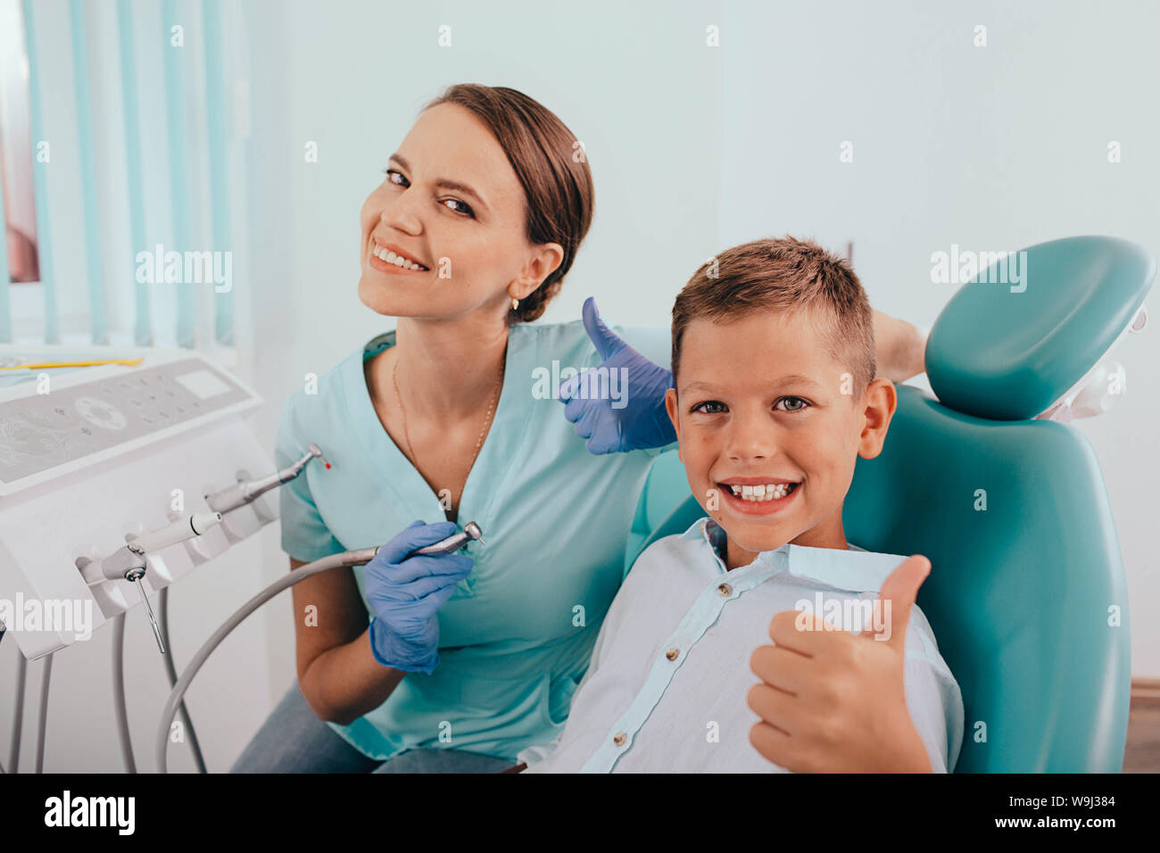 Cute Boy und positive weibliche Zahnarzt mit Daumen nach oben. Kind zahnmedizinische Behandlung Stockfoto