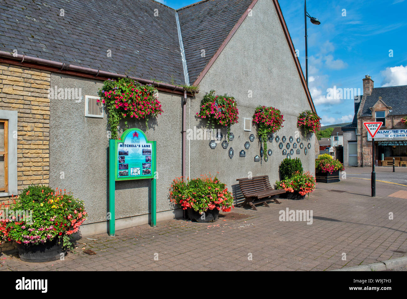 ALNESS ROSS UND CROMARTY SCHOTTLAND DORF STADT IN VOLLER BLÜTE EINE WAND DER HÄNGENDE KÖRBE UND GEWINNEN TROPHÄE PLAKETTEN Stockfoto