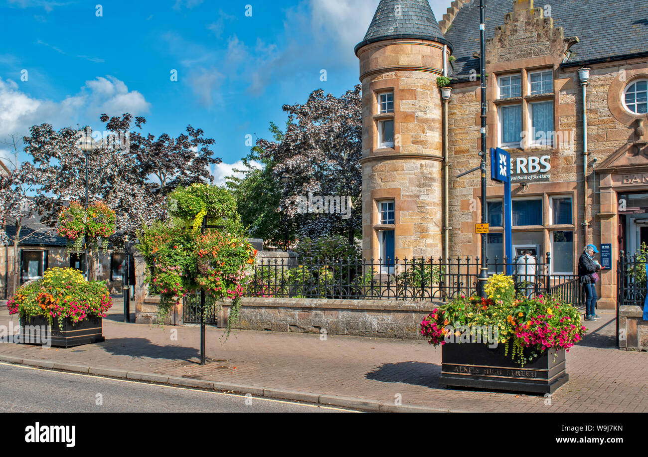 ALNESS ROSS UND CROMARTY SCHOTTLAND DORF STADT IN VOLLER BLÜTE bunte Blumen in hängende Körbe UND BEHÄLTER AUSSERHALB DER ROYAL BANK OF SCOTLAND BUILDIN Stockfoto