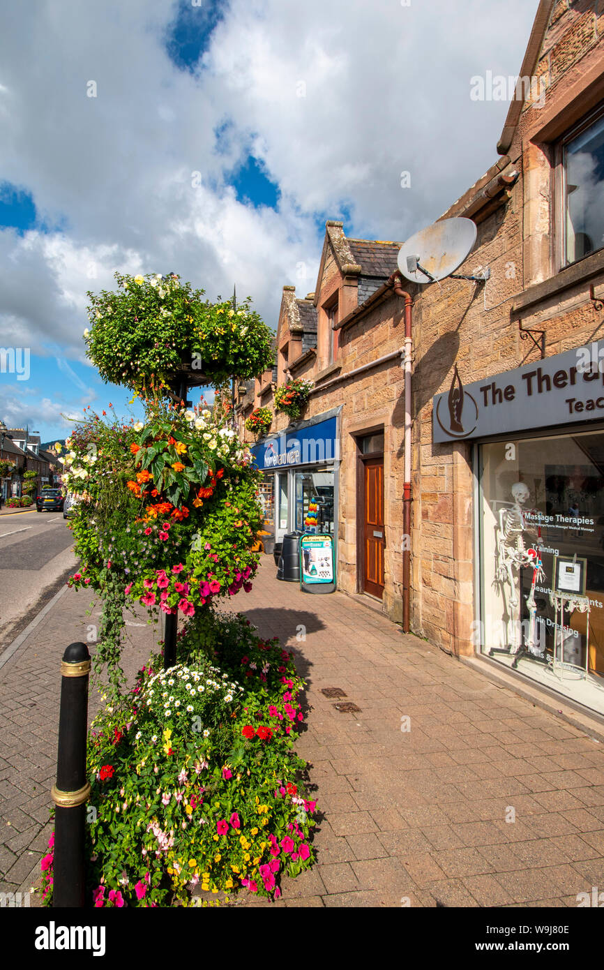 ALNESS ROSS UND CROMARTY SCHOTTLAND DORF STADT IN VOLLER BLÜTE hervorragende Darstellung von bunten Blumen unter GESCHÄFTE IN DER HIGH STREET Stockfoto