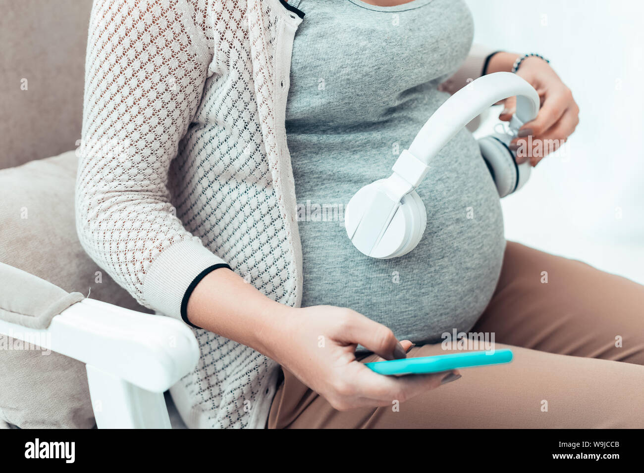 Entspannt schwanger weibliche Person Hören von Musik Stockfoto