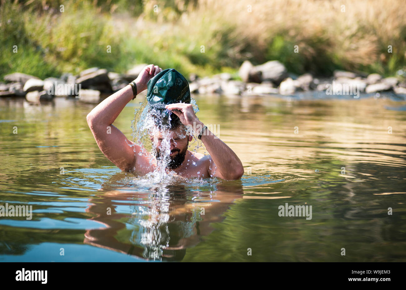 Mann in einem Fluss Abkühlung an einem heißen Sommertag Stockfoto
