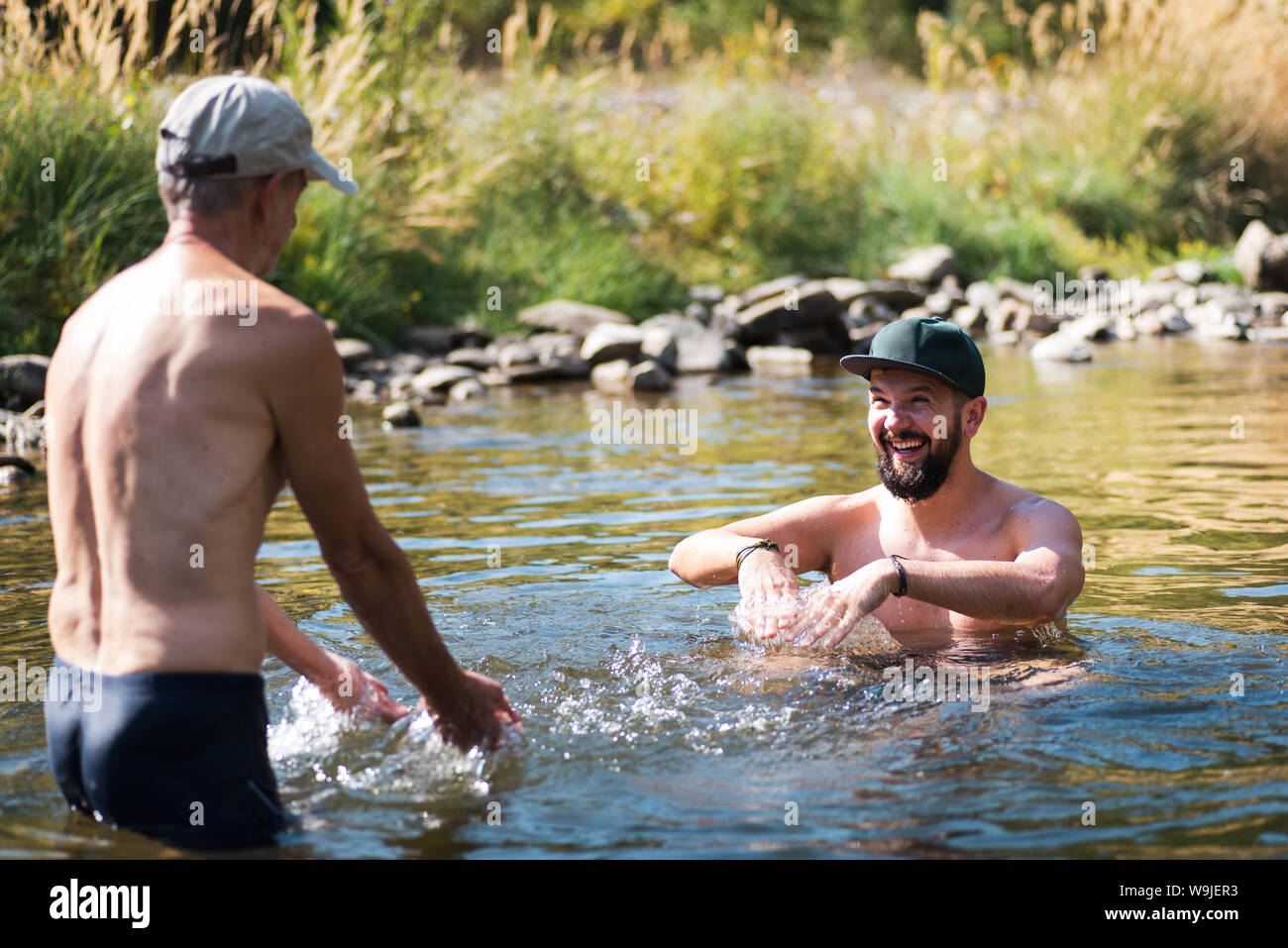 Vater und Sohn Spaß im Wasser des Flusses an einem heißen Sommertag Stockfoto