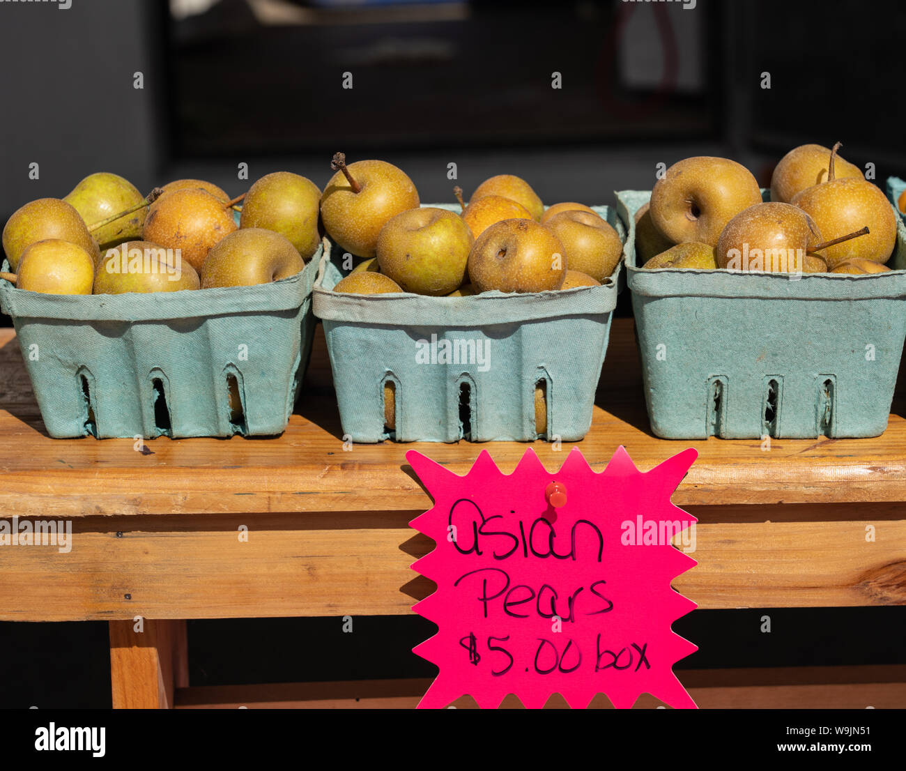 Körbe für asiatische Birnen für den Verkauf auf einem holztisch am Bauernmarkt mit dem Preis Zeichen Stockfoto