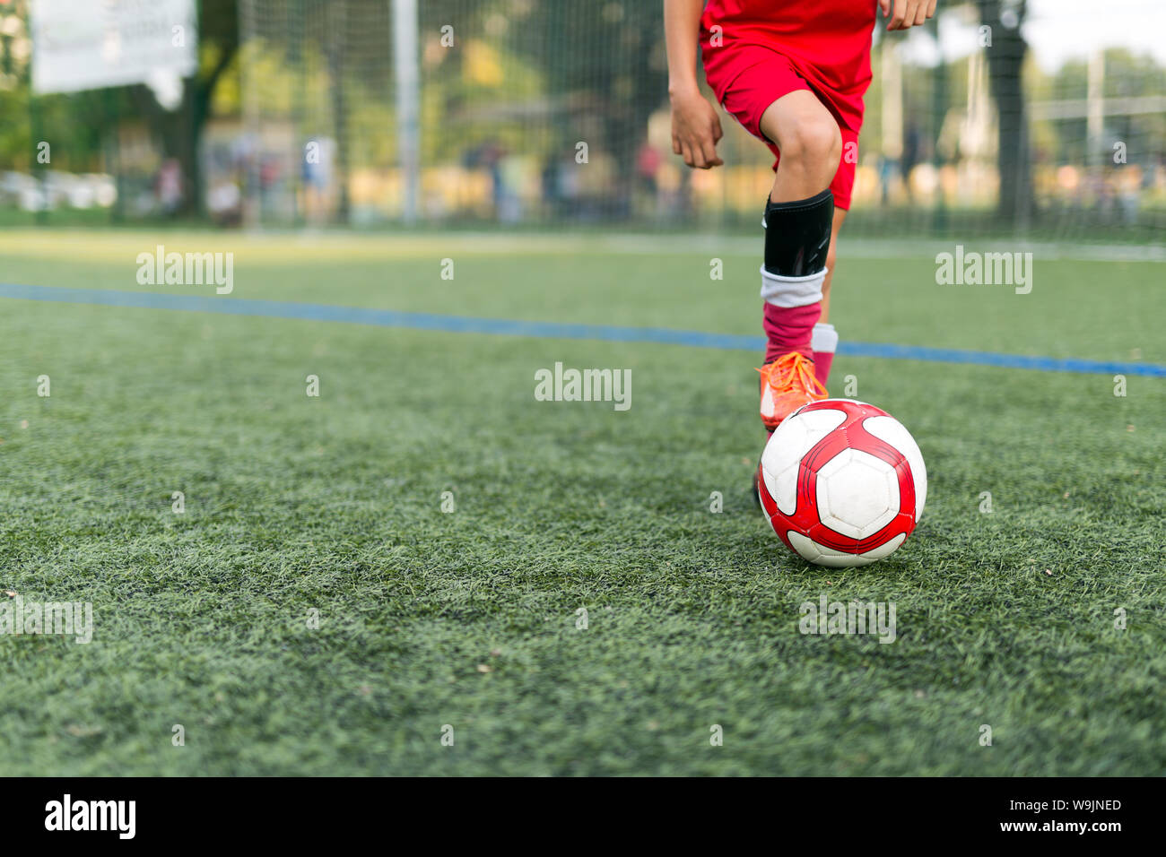 Porträt des Jungen Fußball spielen auf dem Feld Stockfoto