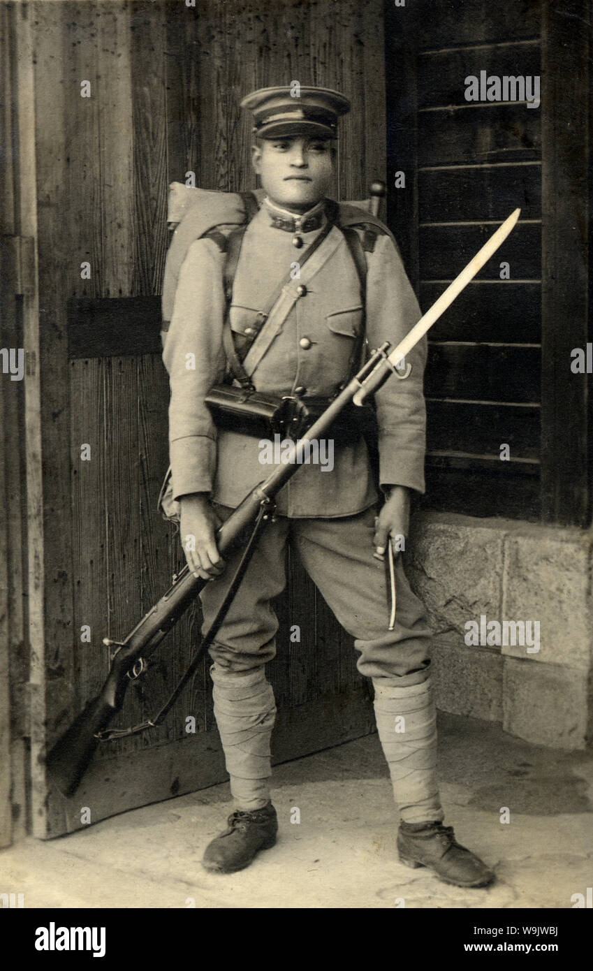 [1930er Jahre Japan - Japanische Soldat mit Gewehr] - Uniformierte japanische Soldat mit einem Gewehr mit Bajonett befestigt. 20. Jahrhundert vintage Silbergelatineabzug. Stockfoto