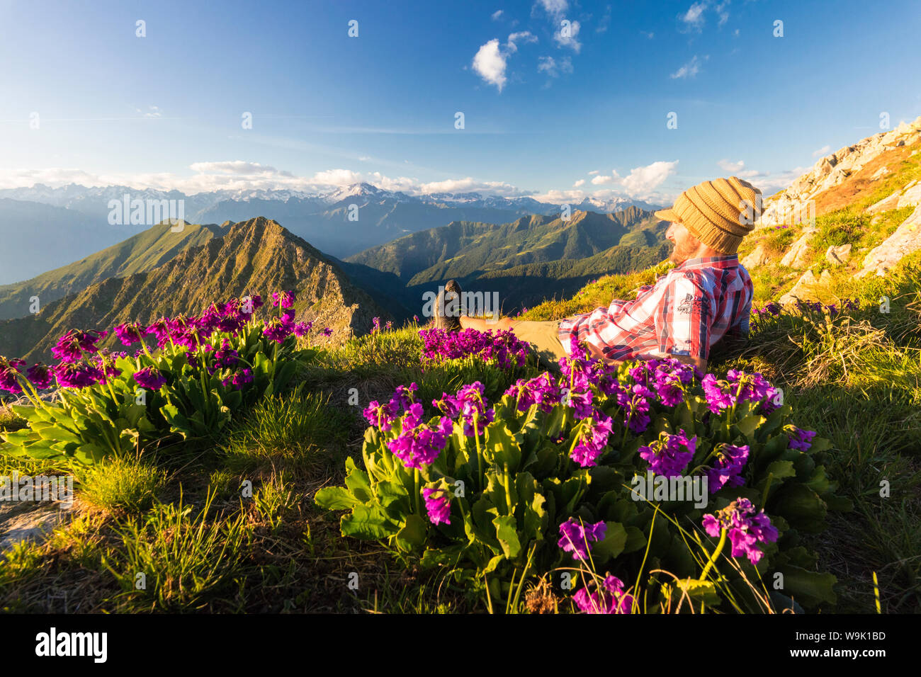 Mann liegen oben auf dem Monte Azzarini schaut in Richtung Monte und Monte Disgrazia, Pedena Albaredo Tal, Bergamasker Alpen, Lombardei, Italien, Europa Stockfoto