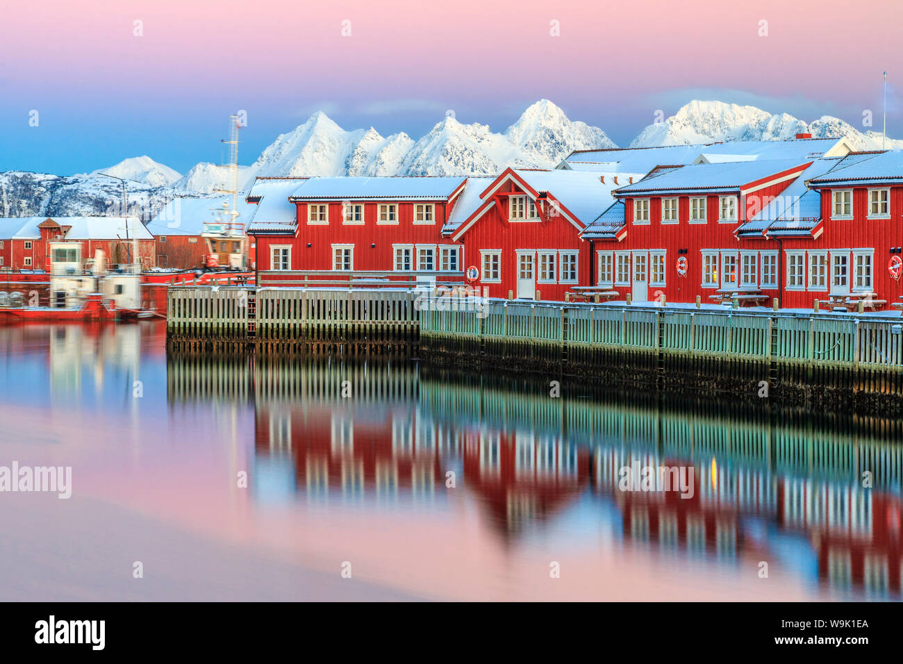 Rosa Sonnenuntergang über die typische rote Häuser spiegelt sich im Meer, Svolvaer, Lofoten-Inseln, Arktis, Norwegen, Skandinavien, Europa Stockfoto