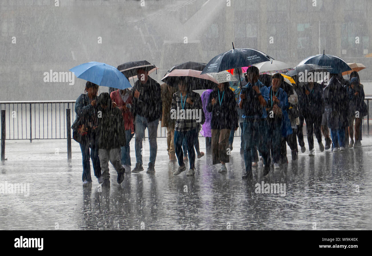 Touristen, gefangen, in, sintflutartiger Regen, South Bank, London Stockfoto