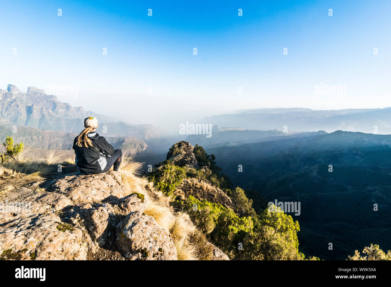 Frau genießen Sie die Morgensonne auf den Klippen, Simien Mountains National Park, UNESCO-Weltkulturerbe, Debarq, Äthiopien, Afrika Stockfoto
