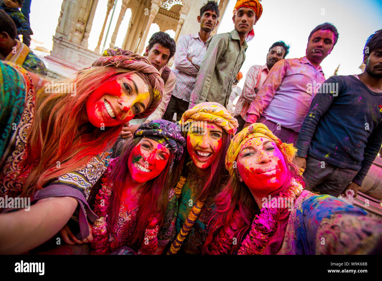 Weibliche Touristen stehen vor Tempel während das Pigment wirft Holi Festival, Vrindavan, Uttar Pradesh, Indien, Asien Stockfoto