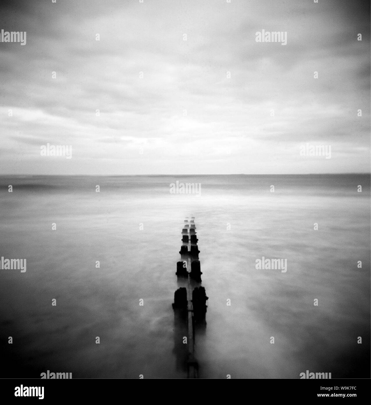 Nordsee bei Dämmerung mit Meerblick Waschmaschine um alte hölzerne Buhnen, Alnmouth, Northumberland, England, UK, Europa Stockfoto