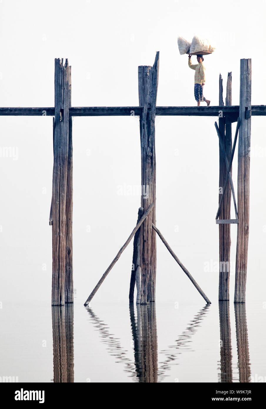 Lokale Frau waren, die ihr Kopf über U-Bein Brücke aus Teakholz Fuß Brücke über den Taungthaman See, Amarapura, in der Nähe von Mandalay, Myanmar Stockfoto