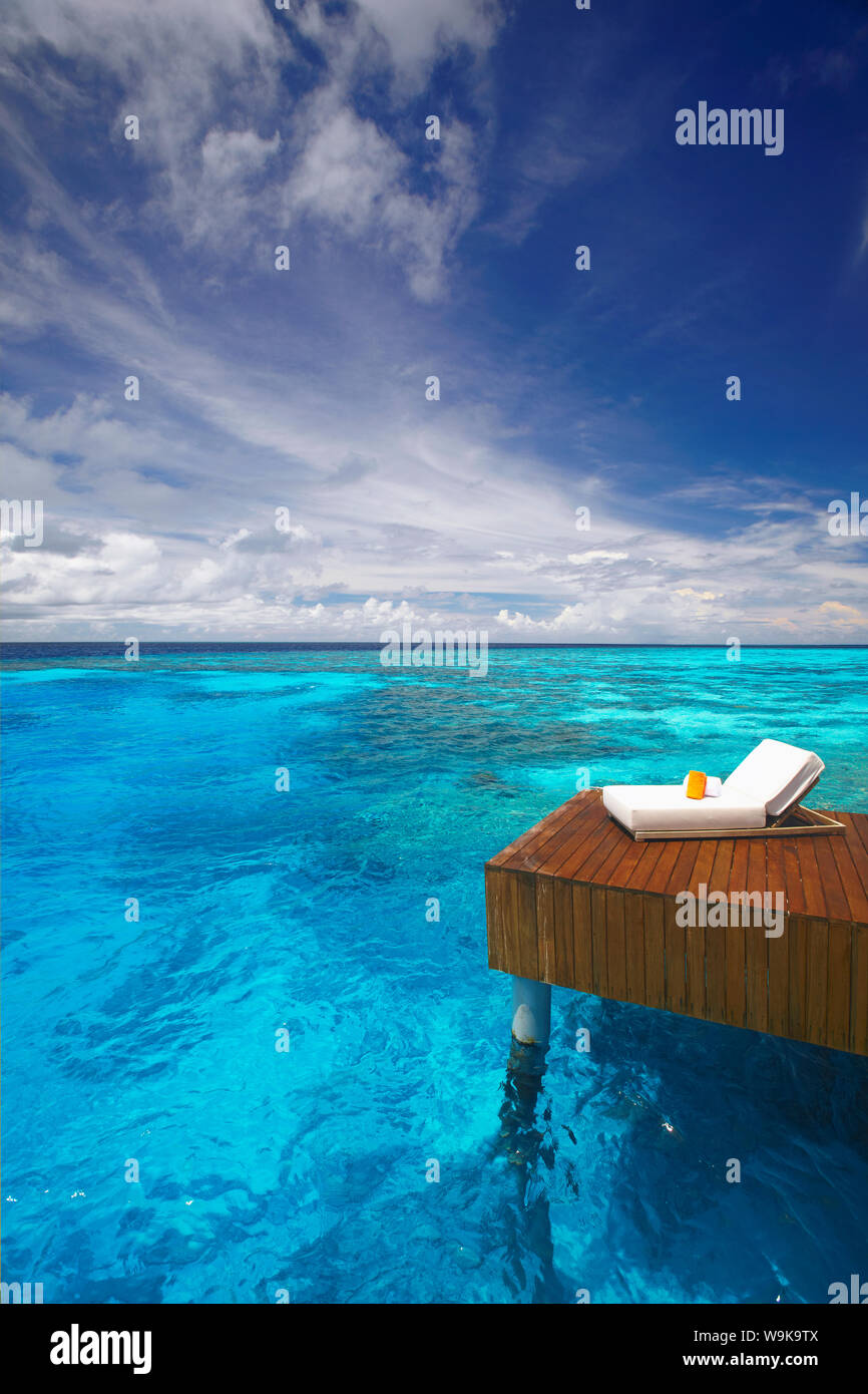 Sonnenliege und Steg in der blauen Lagune, Malediven, Indischer Ozean, Asien Stockfoto