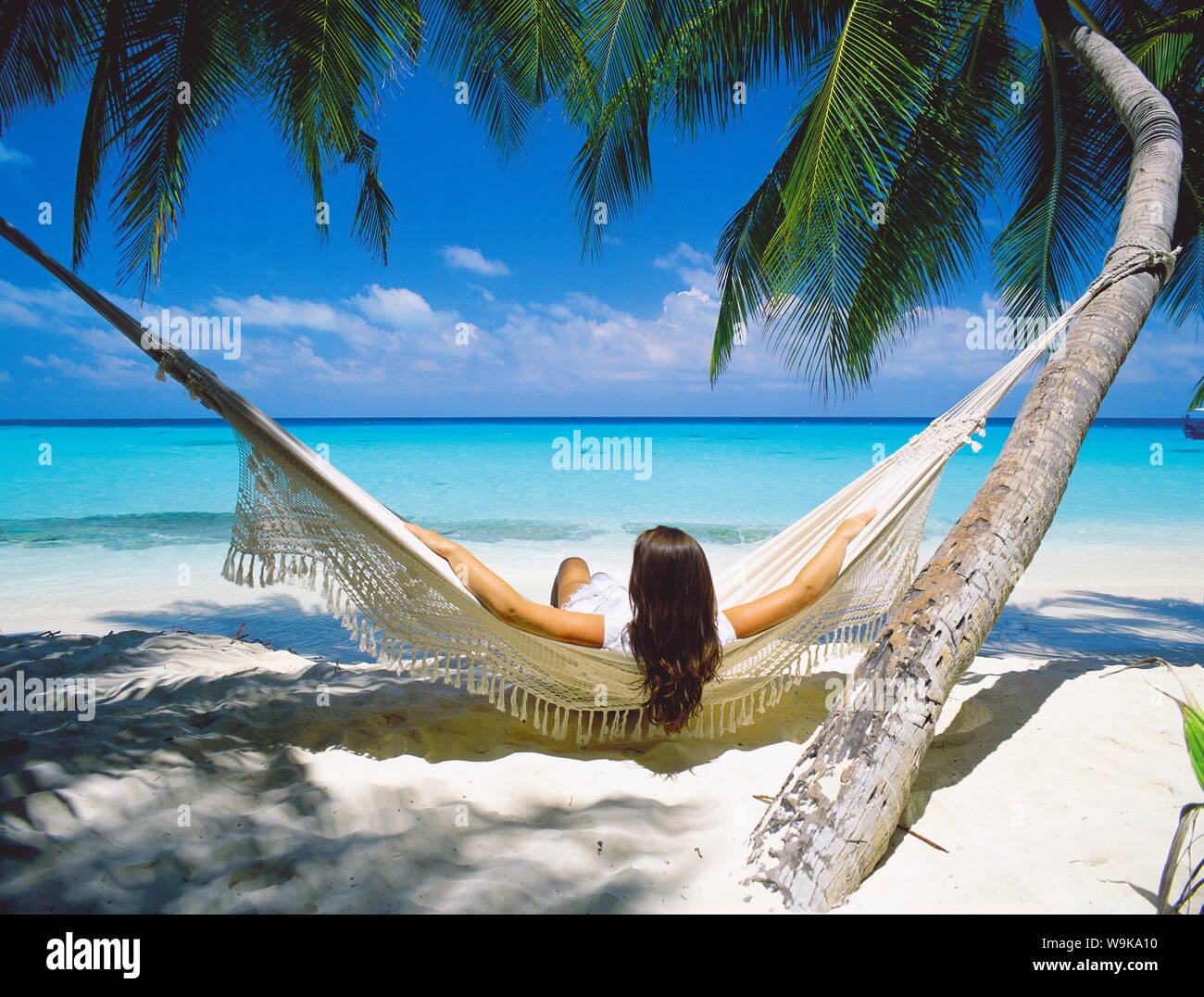 Frau sitzt in der Hängematte am Strand, Malediven, Indischer Ozean, Asien Stockfoto