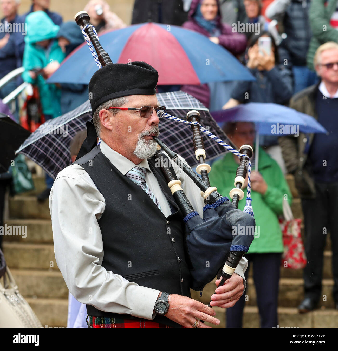 Glasgow, Schottland, Großbritannien. 14. Aug 2019. Das 16. Jahr der Glasgow International Piping Festival weiterhin mit kostenlosen Konzerten in Buchanan Street aus einer Auswahl von Pipe Bands einschließlich der Kanadischen und Amerikanischen genossen von 100 von den Zuschauern, die sich nicht von der schwere Regen gestellt wurden. Piper mit der Grande Prairie und District Pipes und Drums, Kanada Kredit: Findlay/Alamy leben Nachrichten Stockfoto