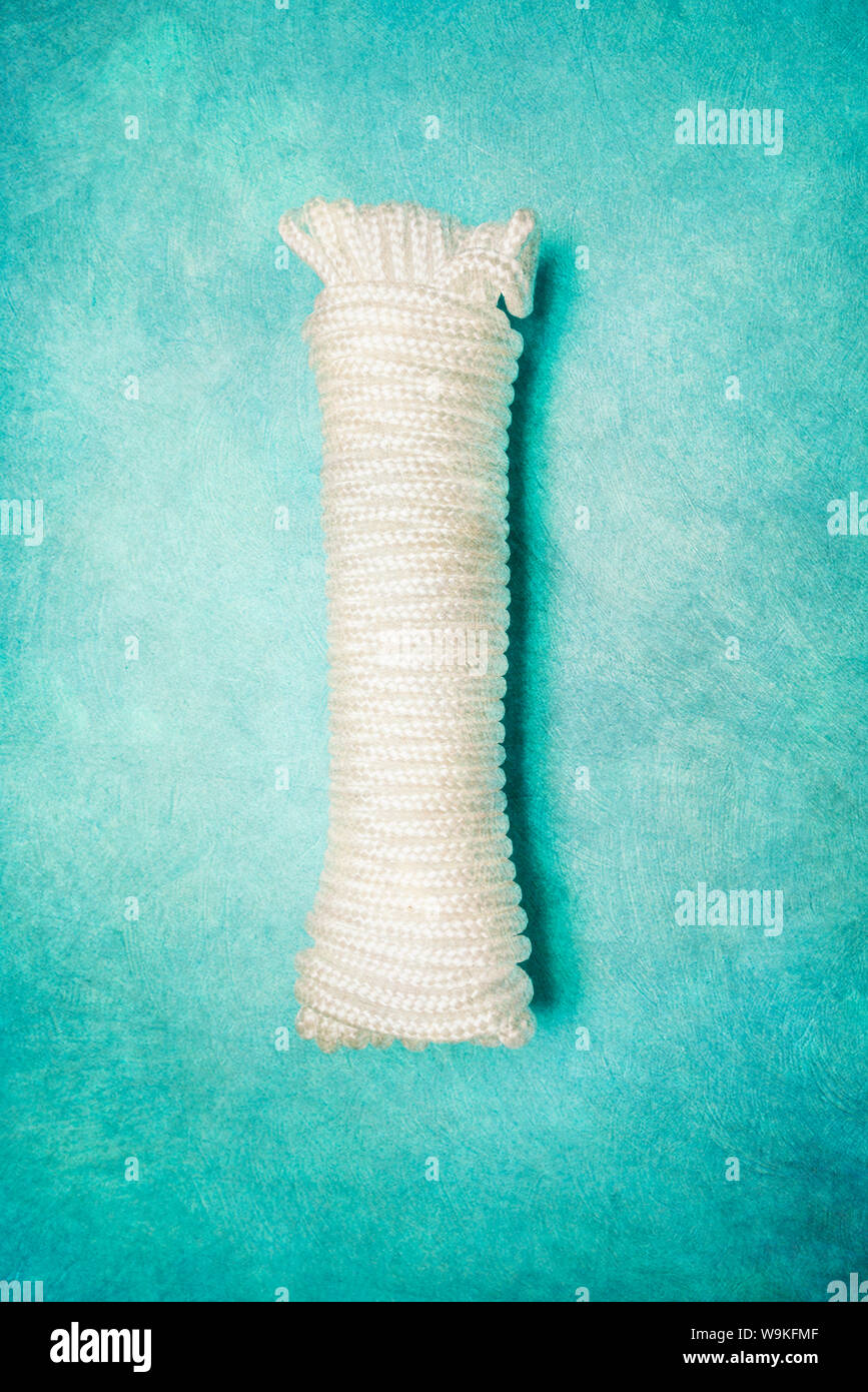 Ein Spiralkabel Länge des weißen Seil gegen einen türkisen Hintergrund. Stockfoto