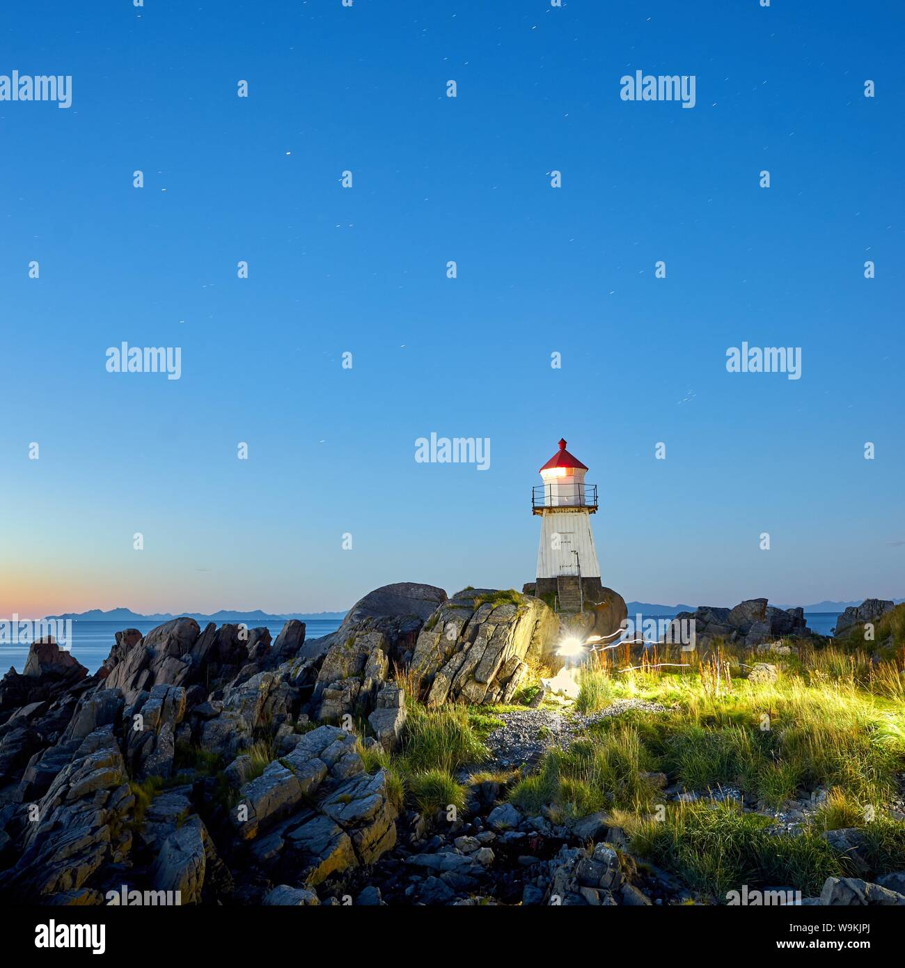 Ein magischer Moment in Norwegen. Ich fand diesen Leuchtturm auf den Lofoten. Eine Familie läuft in meinem Bild. Stockfoto