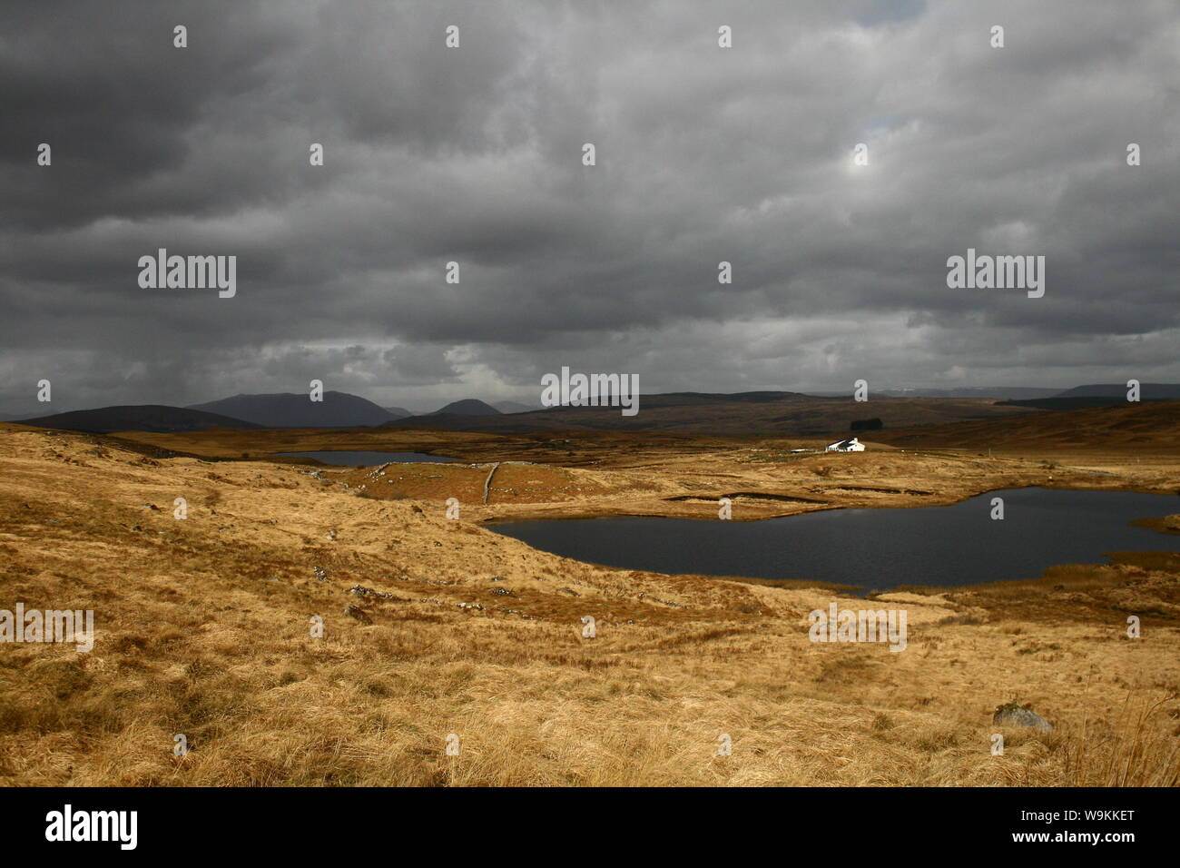 Moody Irish Landschaftsbild mit See und sehr dunklen und ominösen Wolken über den Bergen von Connemara, Irland Stockfoto