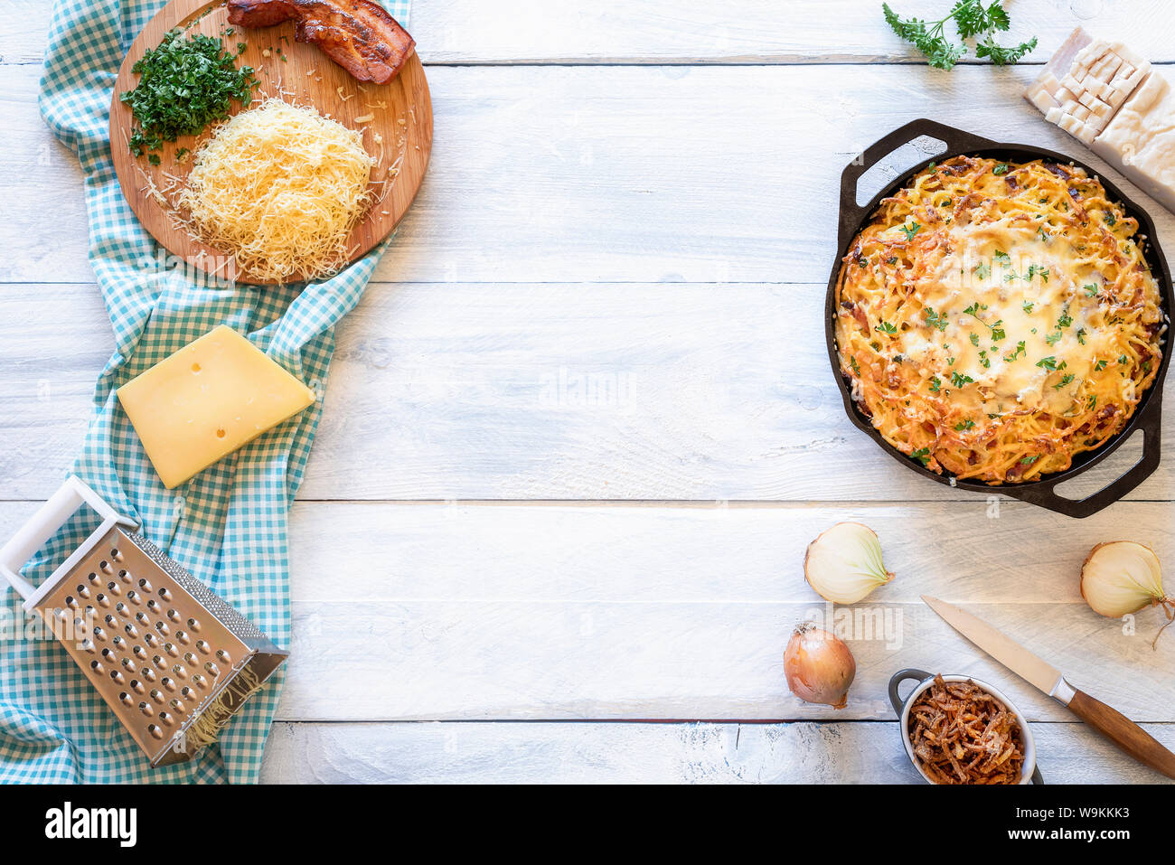 Bayerischen Käse Pasta mit Zwiebel und Speck auf einem weißen Tisch mit Zutaten. Oben Ansicht der Deutschen traditionellen Oktoberfest essen. Schwäbischen Abendessen Gericht. Stockfoto