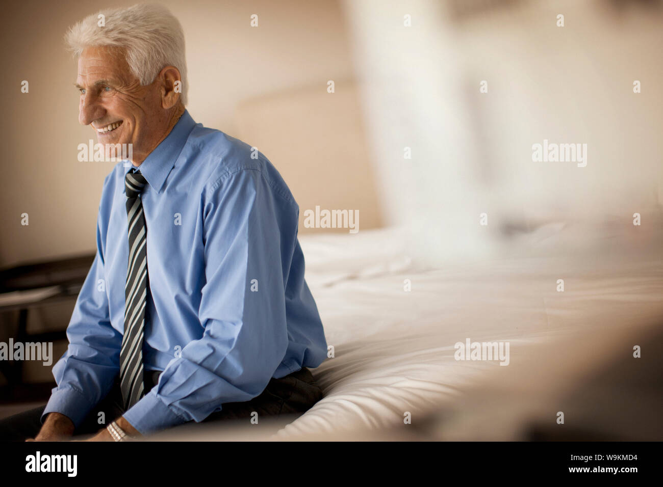 Senior Geschäftsmann, Lächeln, während er auf dem Bett. Stockfoto