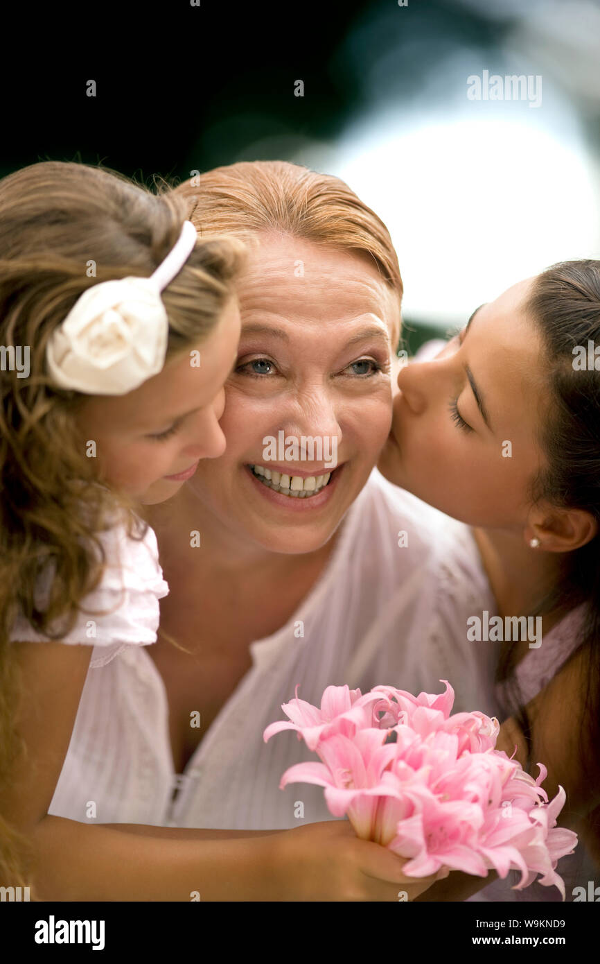 Zwei junge Mädchen küssen Wangen ihrer Großmütter. Stockfoto