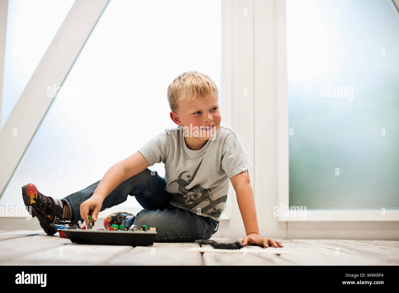 Junge spielt mit seinem Spielzeug auf dem Boden. Stockfoto