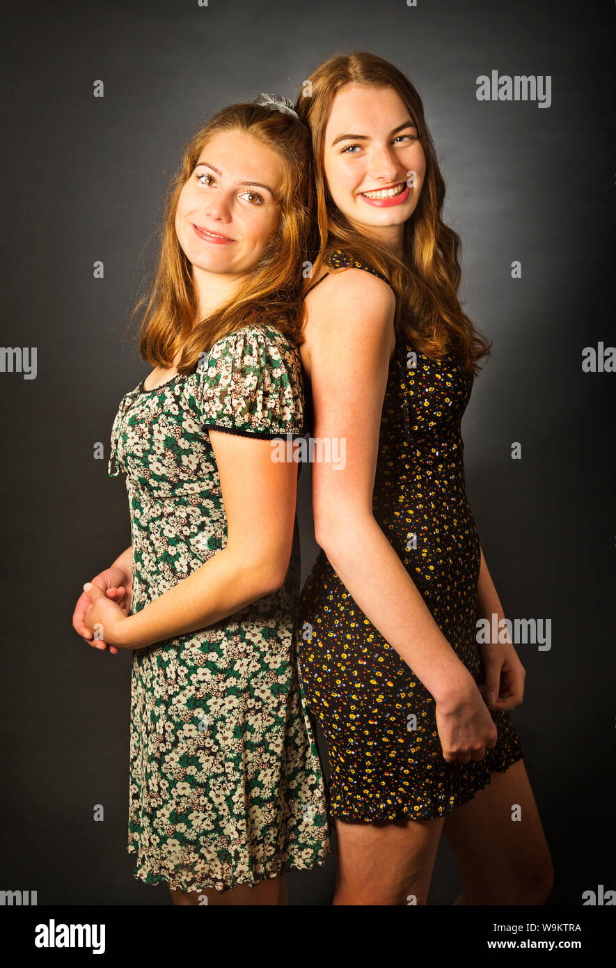 Zwei Mädchen im Teenager-Alter Rücken an Rücken in einem Studio Stockfoto