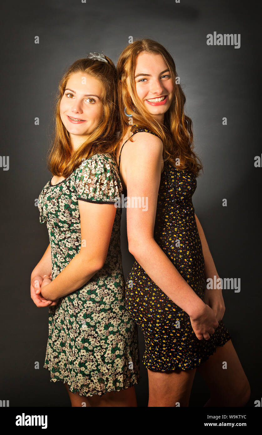 Zwei Mädchen im Teenager-Alter Rücken an Rücken in einem Studio Stockfoto