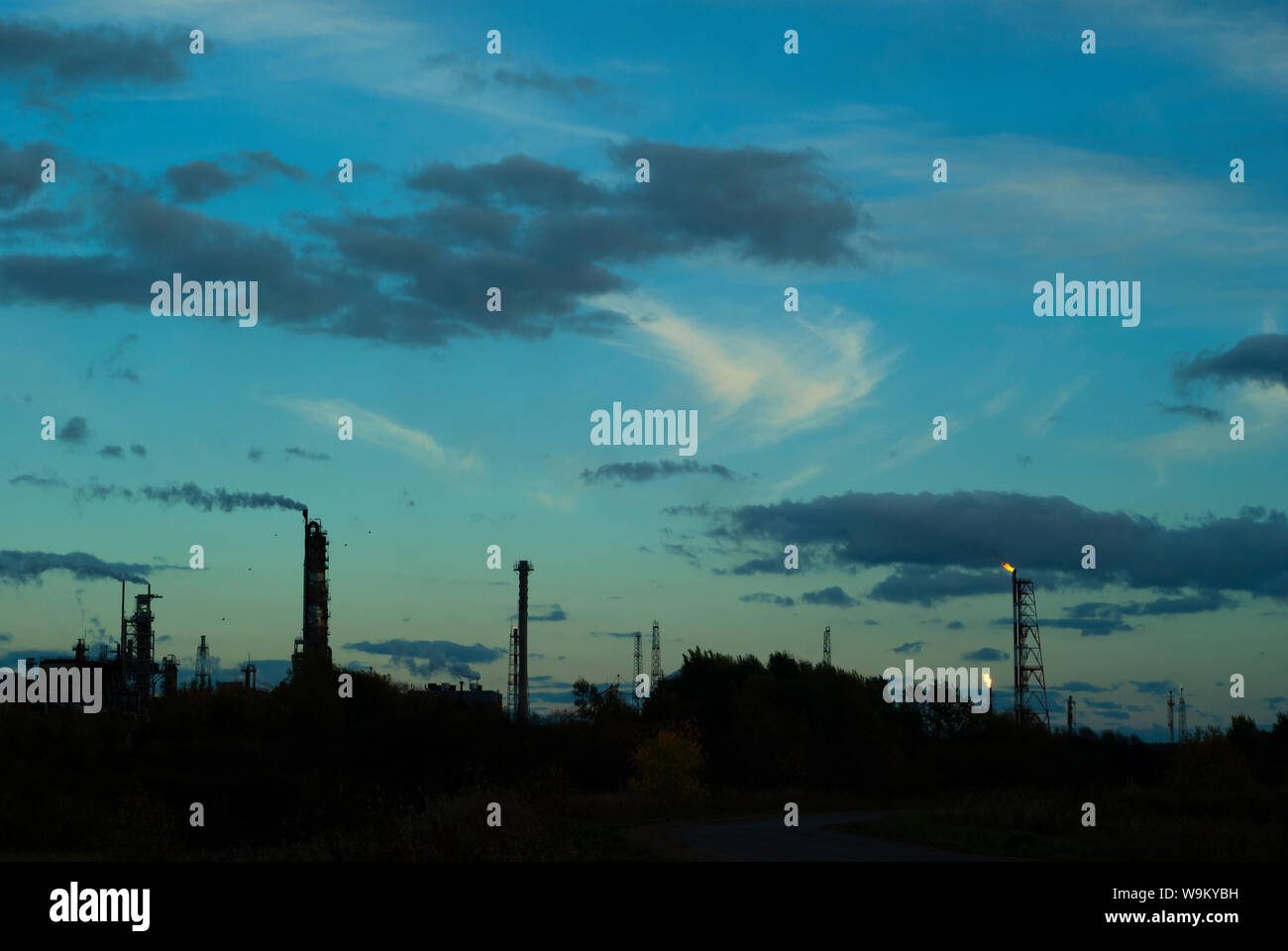 Silhouette industrielle Landschaft mit industriellen Fackeln und Fraktionierung Spalten vor dem Hintergrund eines dunklen Abendhimmel Stockfoto