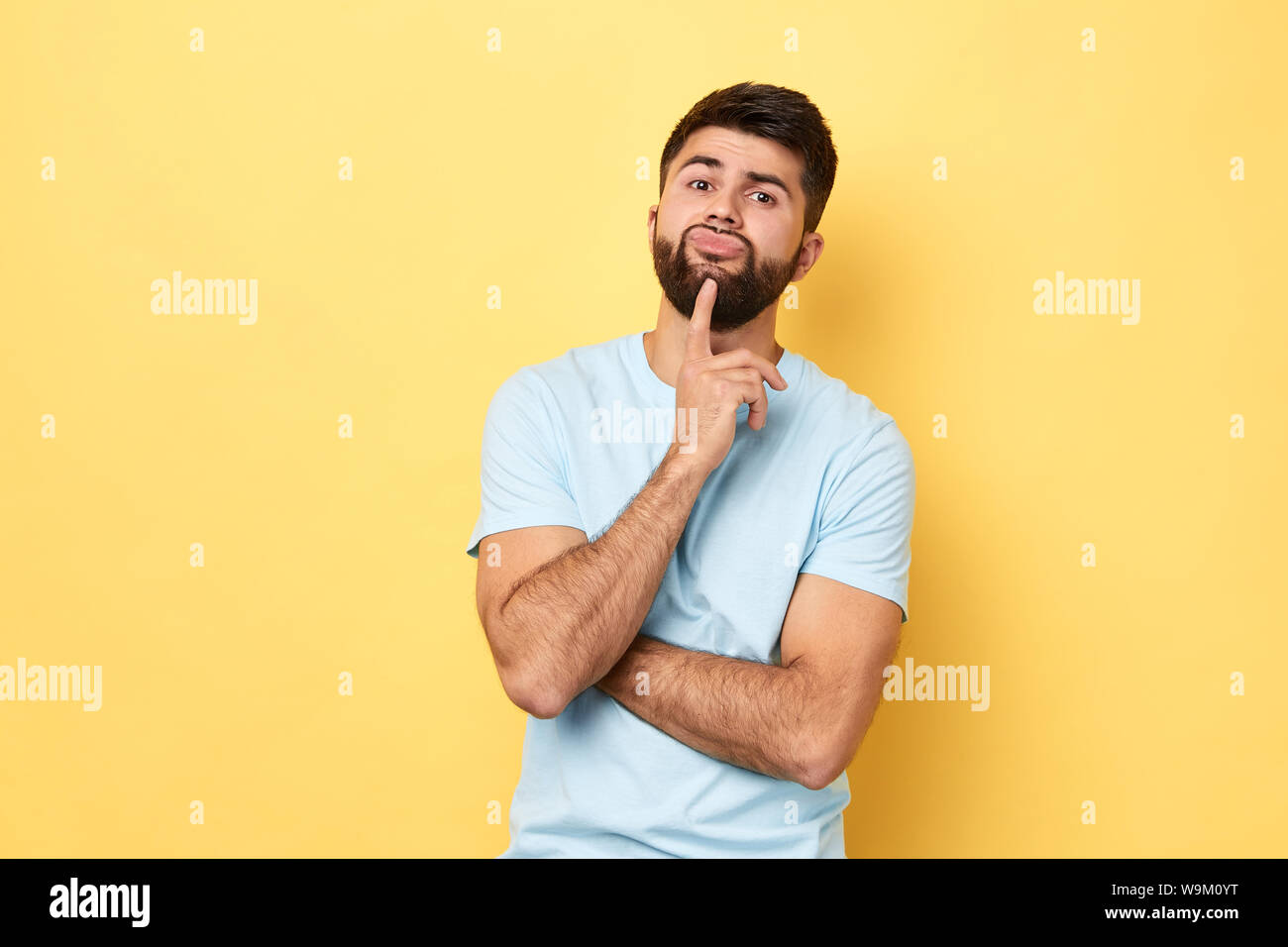 Nachdenklich ernsten Kaukasischen jungen Mann berührt Kinn mit Finger denken oder in Betracht, Guy Entscheidung zu treffen oder sich vorzustellen. close up Portrait. Isoliert Stockfoto