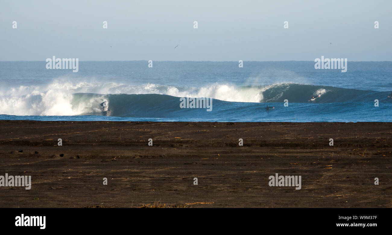 Surfer reiten Wellen an einem Point Break im Nuble region, Chile Stockfoto