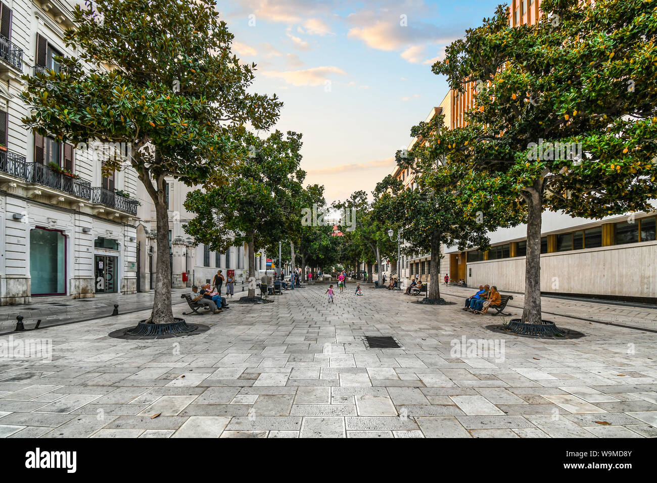 Am späten Nachmittag dreht sich in der Dämmerung auf der Piazza della Vittoria, wie Familien, die Sie für den Abend Passeggiata in Brindisi, Italien, Teil der Region Apulien Stockfoto