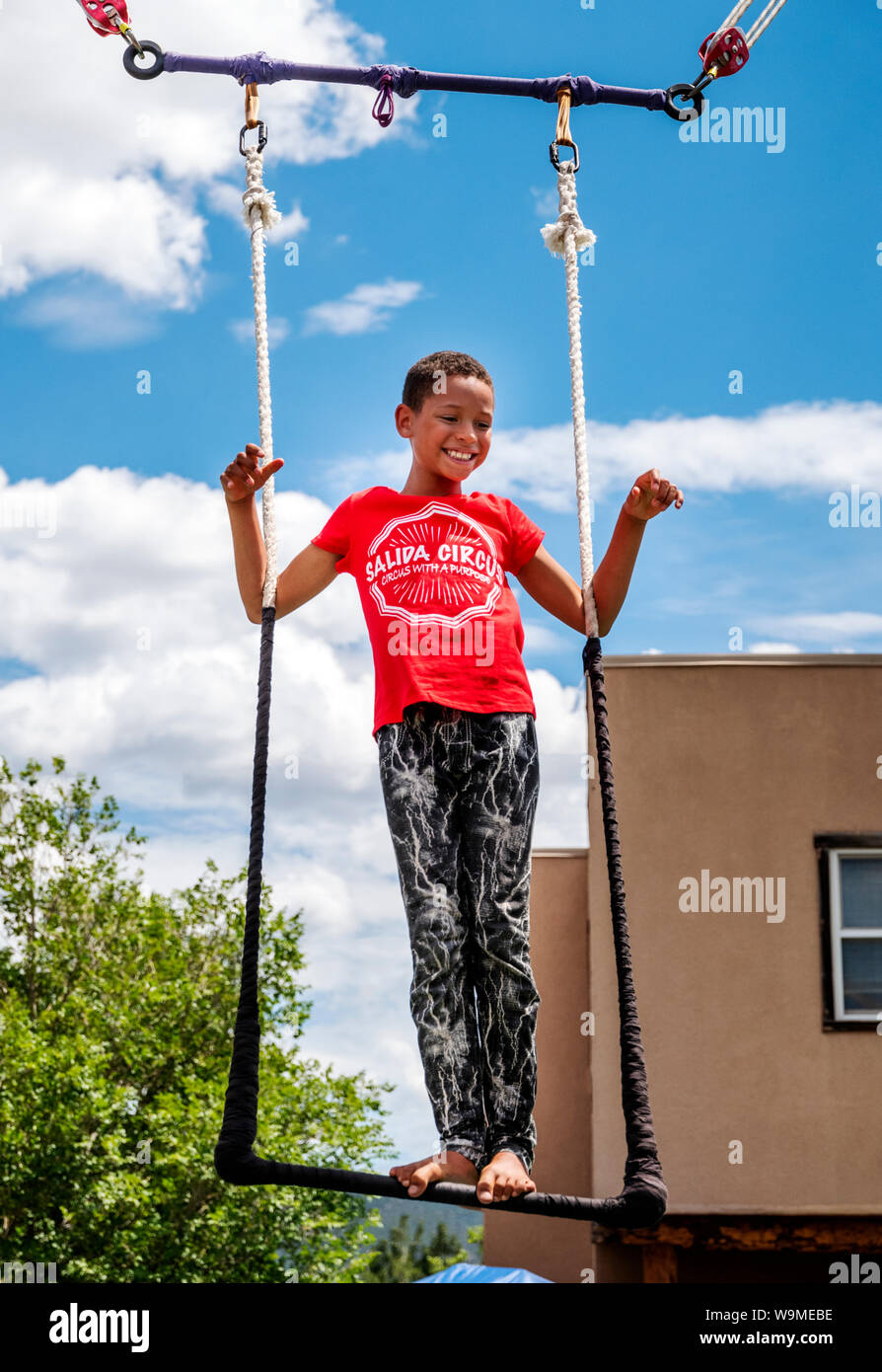 Junge afrikanische American Boy auf Trapez; Salida Circus Sommer Camp finale; Salida, Colorado, USA Stockfoto