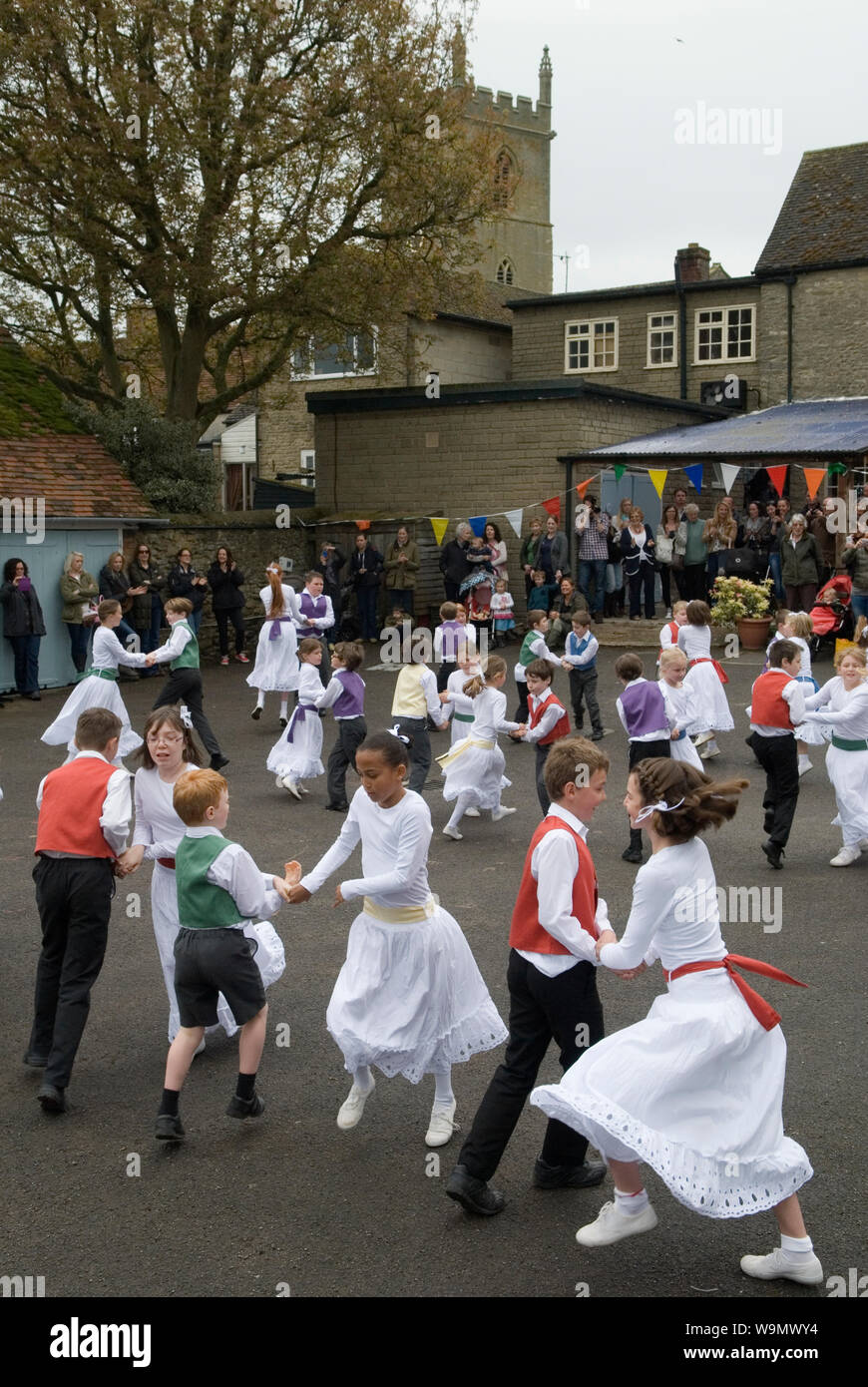 Mai Tag Kinder tanzen UK Charlton-auf-otmoor Oxfordshire Mai Tag feiern. Kinder von der Kirche von England St Maria, der Jungfrau, Grundschule nehmen teil an den traditionellen Mai Tänze auf dem Parkplatz des Crown Inn. 2010 s 2014 HOMER SYKES Stockfoto
