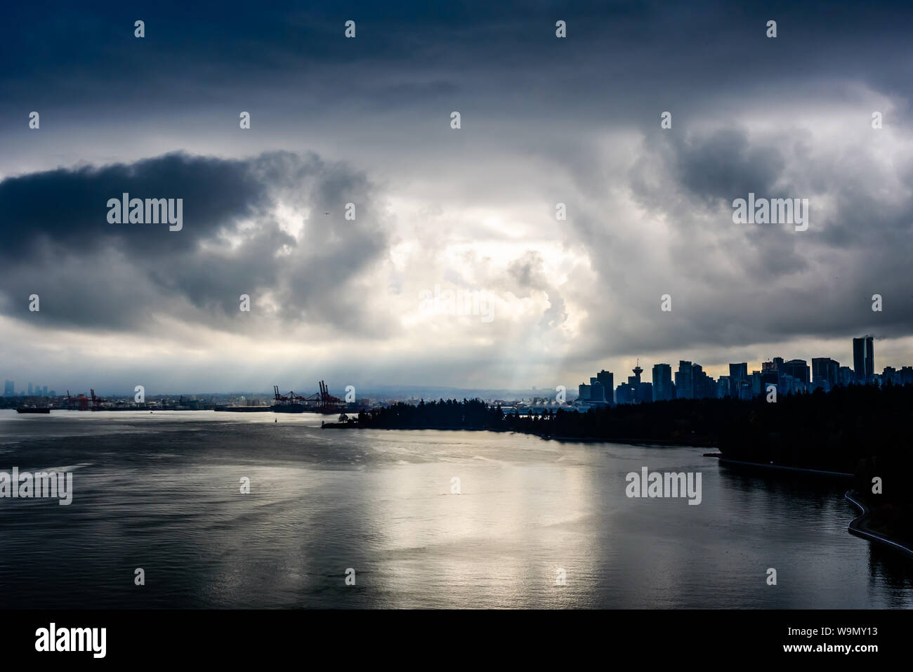 Sonne bricht durch dunkle Wolken im dramatischen Kontrast über Vancouver, British Columbia, Kanada. Stockfoto