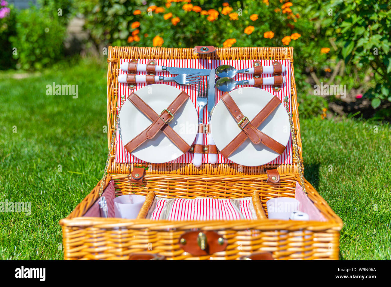 Picknickkorb auf grünen sonnigen Wiese im Park Stockfoto