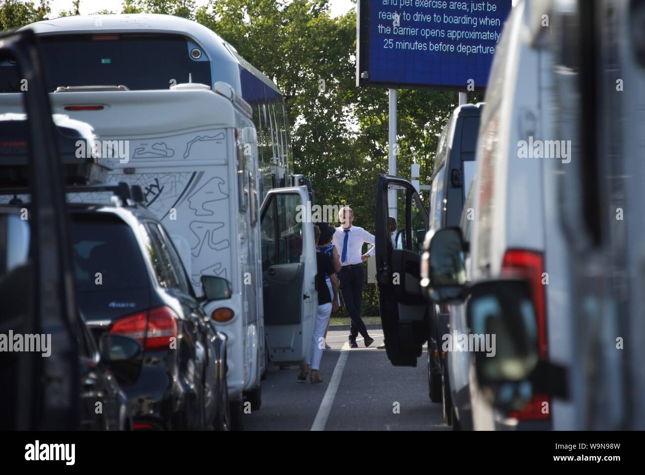 Ein Busfahrer unterhält einige seiner weiblichen Passagiere während der Wartezeit auf den Zügen für Frankreich in der Eurotunnel Folkestone Terminal Stockfoto