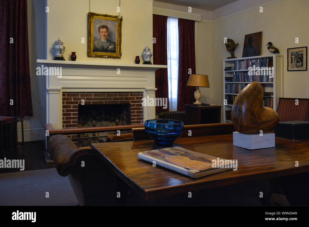 Die Bibliothek mit einem Porträt der Hausbesitzer, Pulitzer Preis ausgezeichnete Autor, William Faulkner, in seiner Residenz, Rowan Oak, Oxford, MS Stockfoto