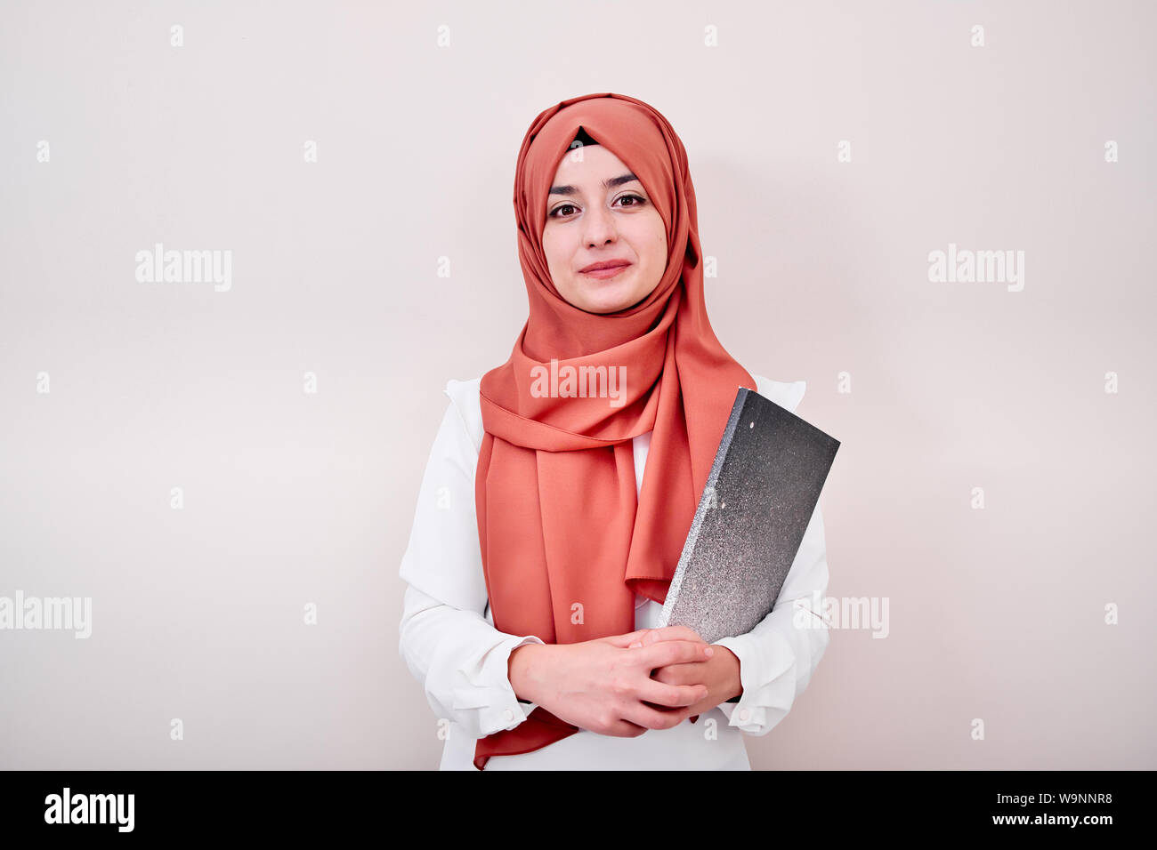 Junge muslimische Mädchen schauen in die Kamera und halten Datei Ordner, zurück in die Schule oder Ausbildung Konzept Foto Stockfoto