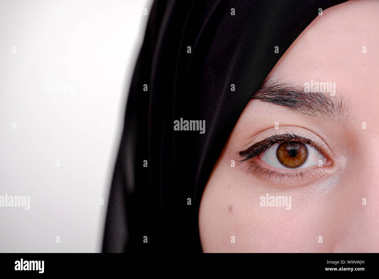 Die Hälfte Portrait von Hijab muslimische Frau, Nahaufnahme der muslimischen Mädchen und sie mit schwarzen Kopftuch oder Schleier Stockfoto