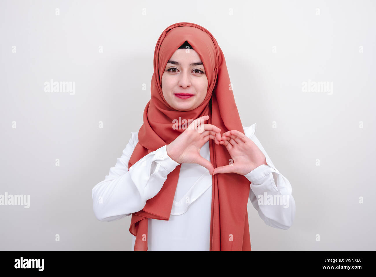 Junge hijab muslimische Frau, die ein Herz Geste mit den Fingern, muslimischen Mädchen Geste liebe herz Zeichen Stockfoto