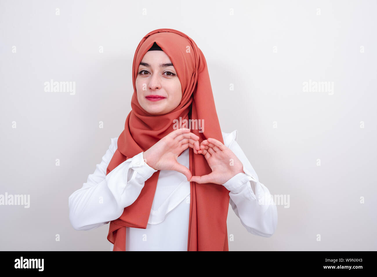 Junge hijab muslimische Frau, die ein Herz Geste mit den Fingern, muslimischen Mädchen Geste liebe herz Zeichen Stockfoto