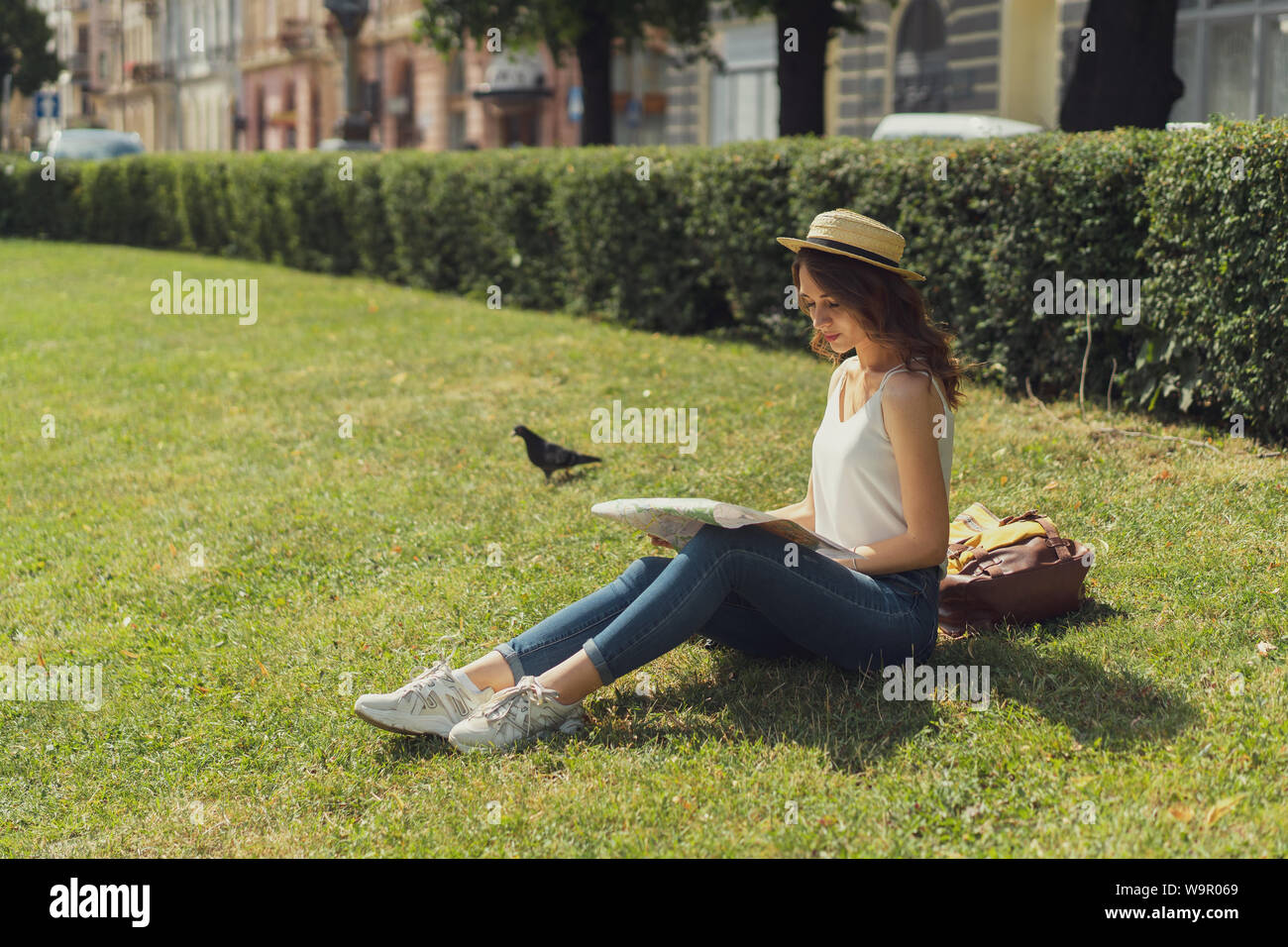 Freiheit und Glück Konzept. Schöne junge Frau hippie Style sitzt auf Gras genießen Sie sonnige Tag im Park. Sommer glücklichen Moment. Stockfoto