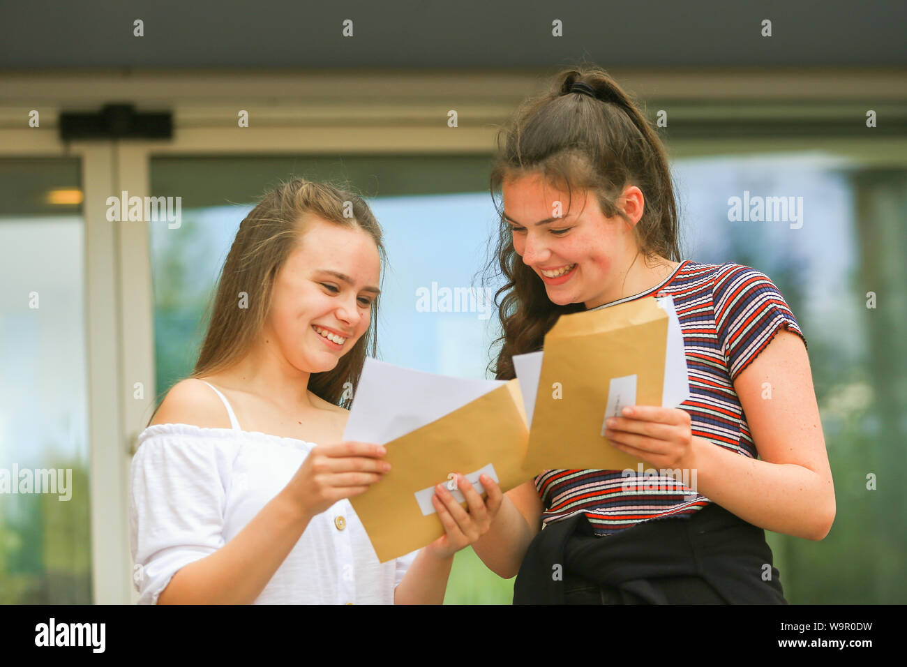 Zwei junge Mädchen mit ihren eine Ebene Prüfungsergebnisse, 2019 Stockfoto