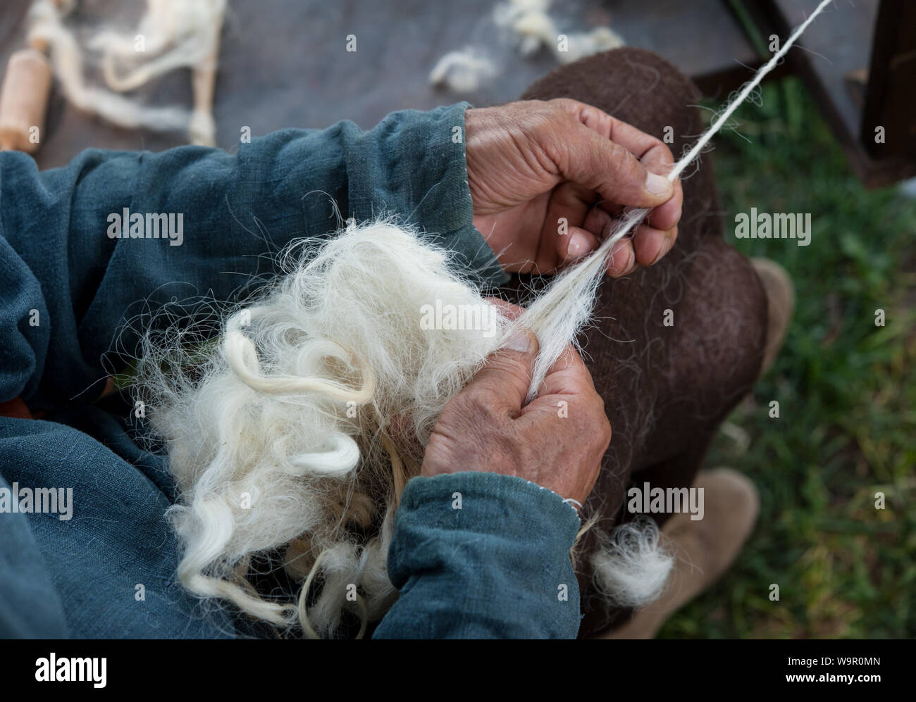 Handwerker mit einem alten Spinnrad wolle in Garn zu drehen. Stockfoto